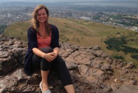 Woman sitting at the top of a mountain