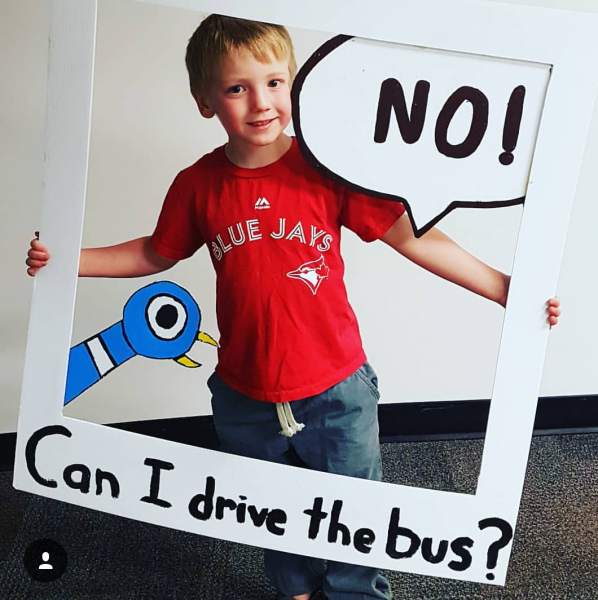 boy holding big cardboard picture frame