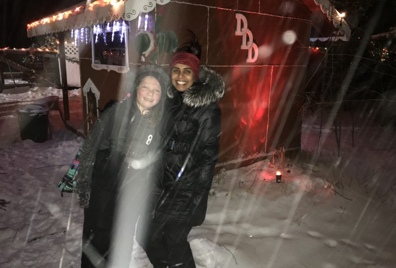 two girls in front of a cabin in the snow