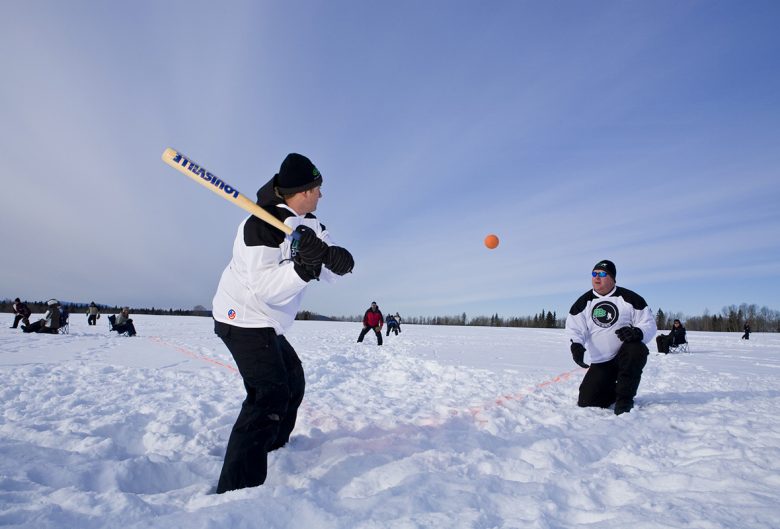 two men playing softball in snow