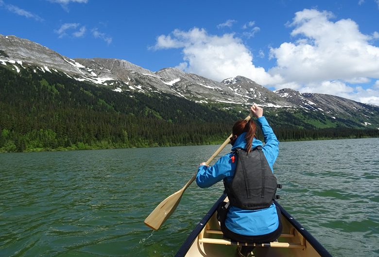 woman canoe lake mountains