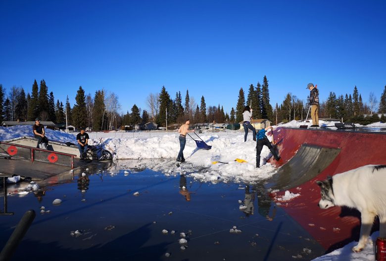 people clearing snow from bike park