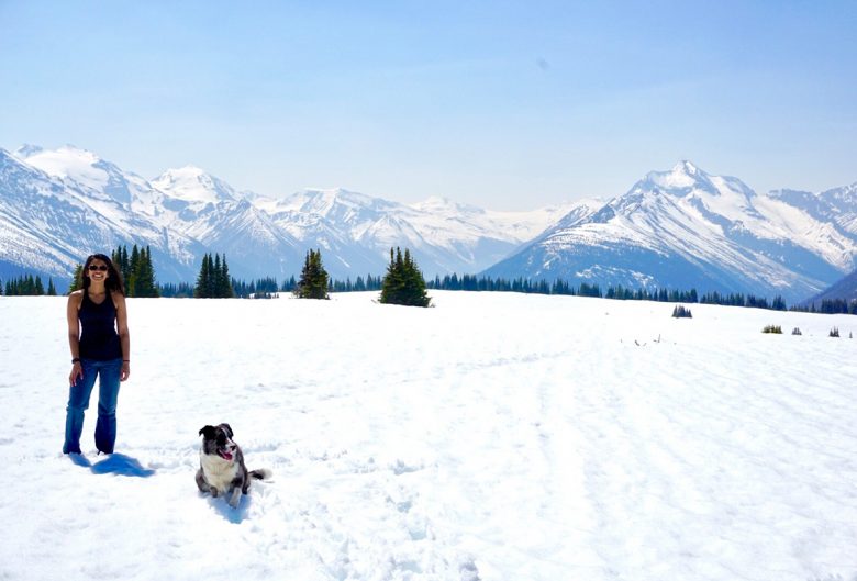 woman and dog in front of mountains