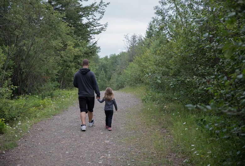 man and girl walking on trail