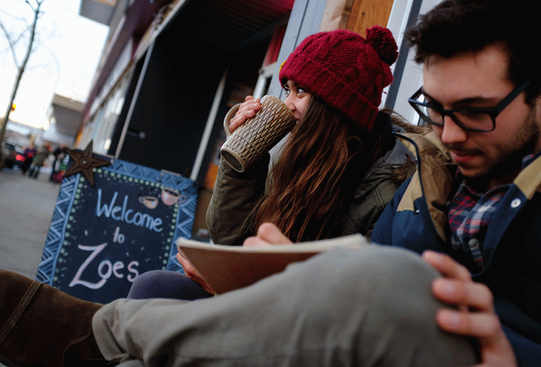 girl drinking coffee while boy draws