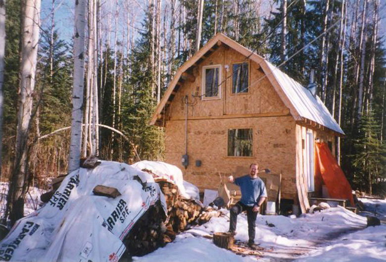 man in front of cabin