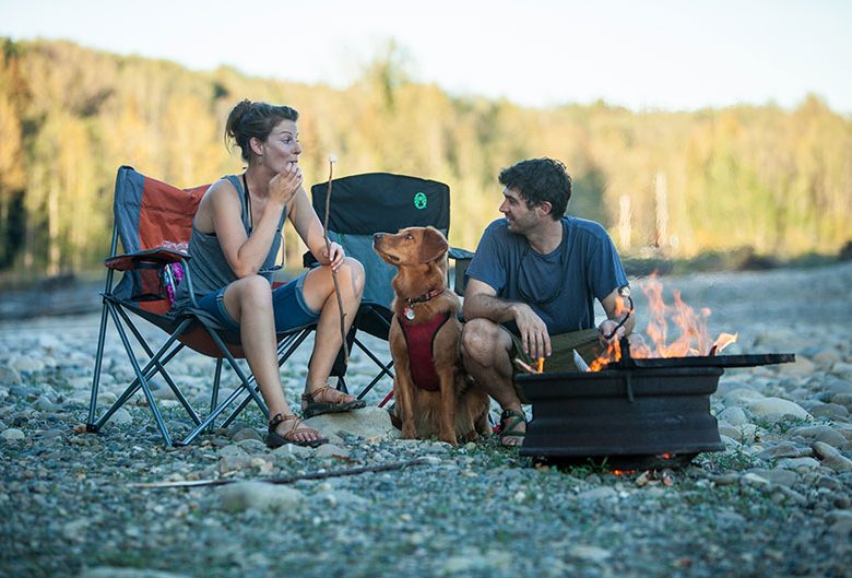 two people dog campfire