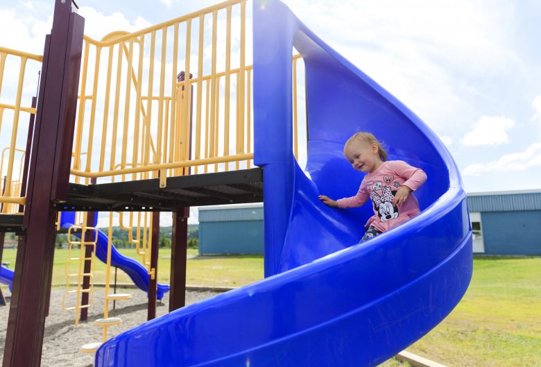 Girl going down slide at a playground.