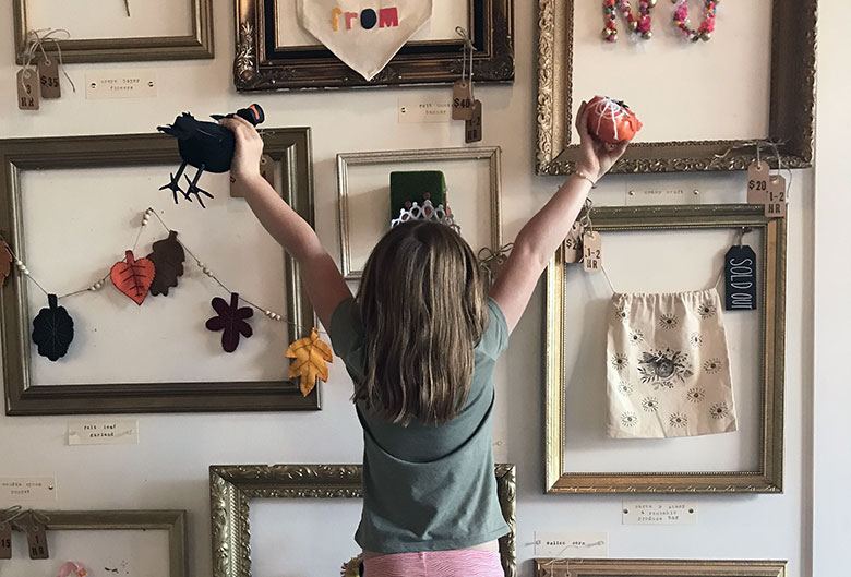 Girl in front of craft wall.