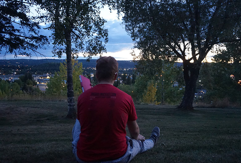 Man sitting on grass in the evening.