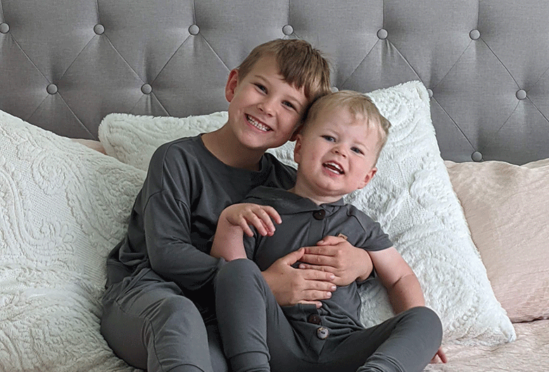 Boys sitting on bed.