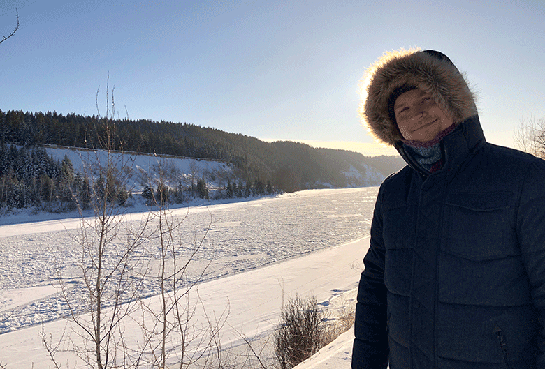 Man standing by snow covered Fraser River.