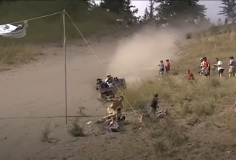 People skiing down a sandbank on a couch.